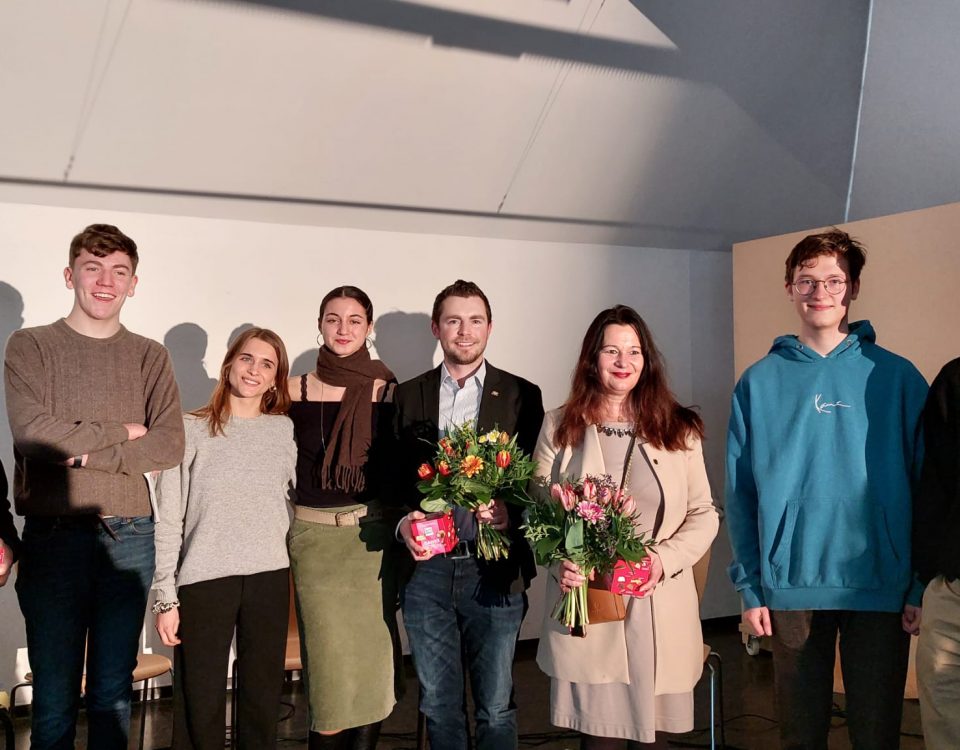 Schüler überreichen Blumensträuße