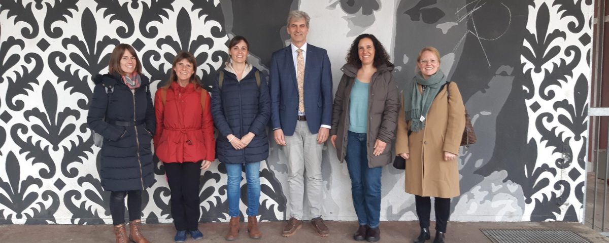 Schulleitende Personen stehen vor Kunstwerk königin olgas