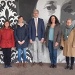 Schulleitende Personen stehen vor Kunstwerk königin olgas