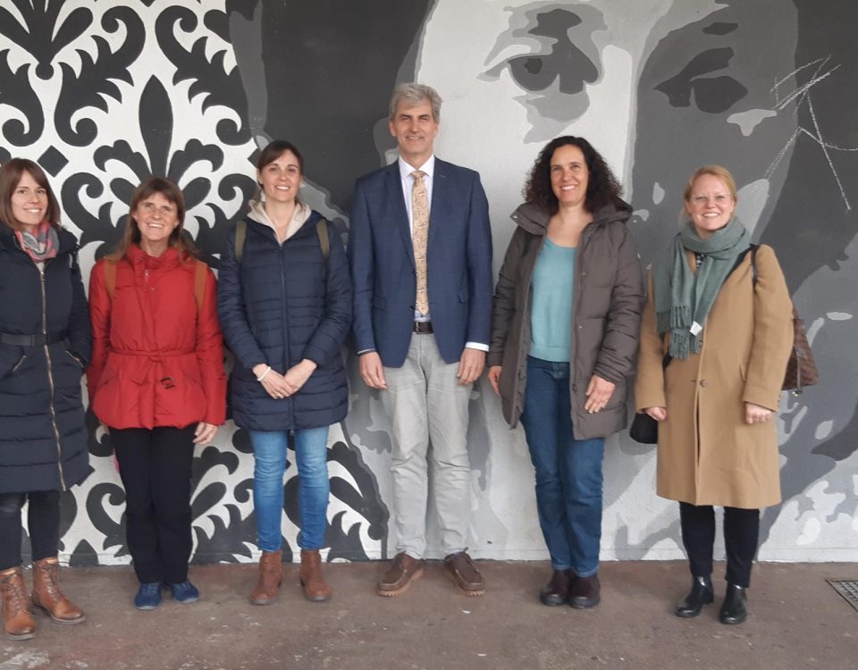 Schulleitende Personen stehen vor Kunstwerk königin olgas