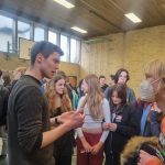 mehrere Schüler unterhalten sich in einer Turnhalle