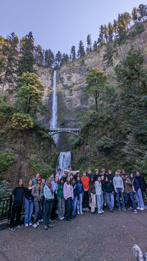 End-of-Oregon-Trail_3 Viele Personen posieren für ein Gruppenbild vor einem Wasserfall in Oregon