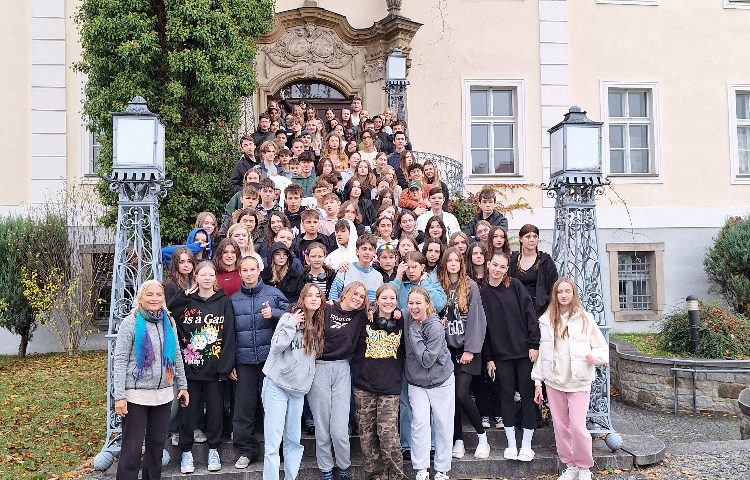 Viele Personen auf einem Gruppenbild vor einem Schloss