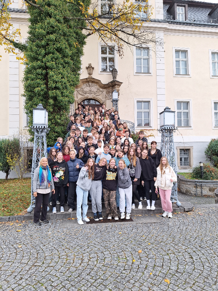 Viele Personen auf einem Gruppenbild vor einem Schloss