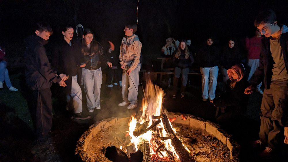 polen_bild_5 Mehrere Personen stehen um ein Lagerfeuer herum